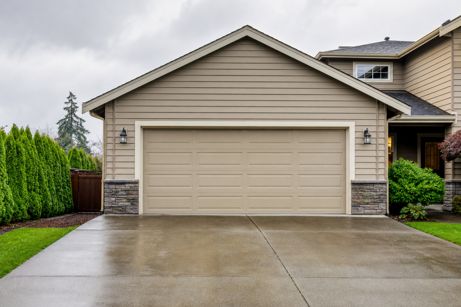 Suburban garage door exterior in Renton with wet driveway on a cloudy day